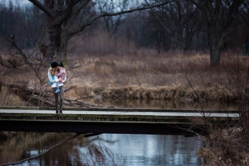 mother and child in front of lake