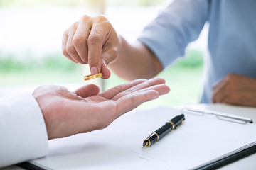 woman placing wedding band in the palm of a man