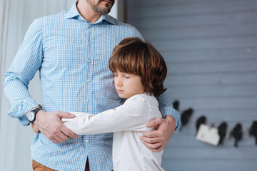 young boy hugging father
