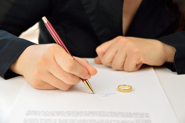 woman signing prenuptial agreement