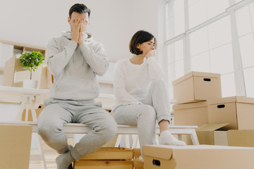 man and woman on couch with boxes behind them