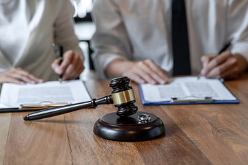 man and woman signing divorce papers with gavel