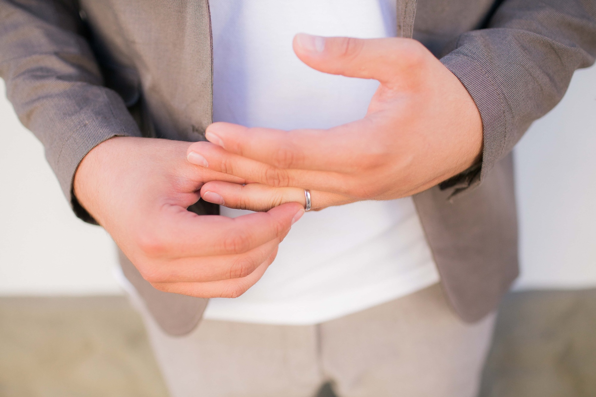 A man removes a wedding ring from a finger of his hand. Bad relationship with his wife. Divorce couples