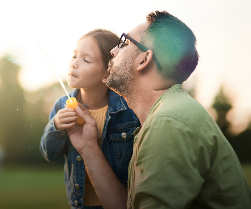 father and daughter blowing bubbles