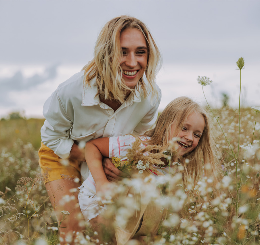 mother playing in a field with her daughter