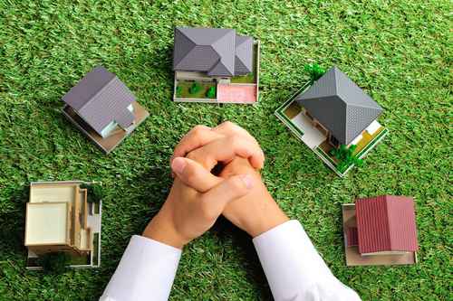 a top down view of the of a man examining miniature homes; Real Estate Attorney in Bay Shore concept image